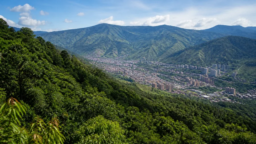 Bosques verdes rodeando el valle urbano de Bello en una mañana despejada