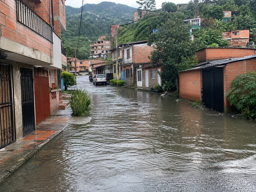 Calle residencial con acumulación de agua durante una lluvia en un barrio de montaña